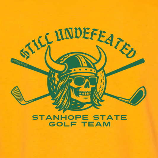 Yellow t-shirt with green graphic of a skull wearing a helmet and sunglasses, crossed golf clubs, and text 'Still Undefeated Stanhope State Golf Team'.