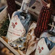 Two bottles of gin in a decorative box with a rustic background